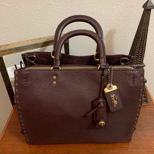 COACH ROGUE WITH RIVETS IN OXBLOOD/BRASS